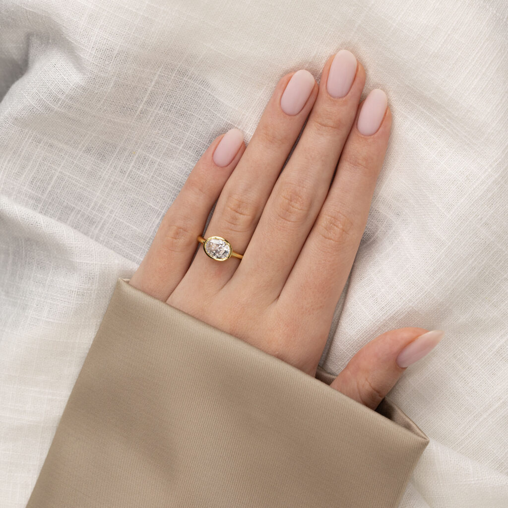 Adore Oval – Elegant East-West Bezel Ring i 18k Gulguld